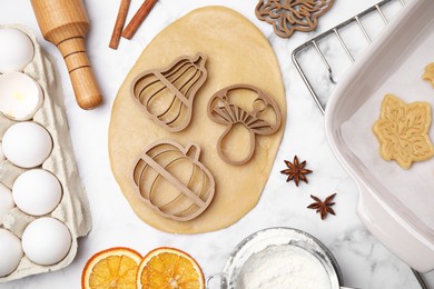 Photo of Flat lay composition with cookie cutters and dough on white marble table