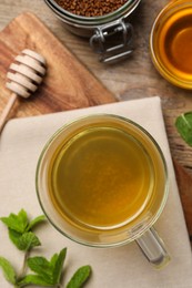 Photo of Buckwheat tea, granules and honey on wooden table, flat lay