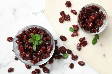 Flat lay composition with tasty dried cranberries on white marble table