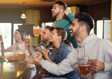 Group of friends watching football in sport bar
