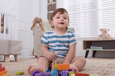 Cute little boy playing with toys in room at home