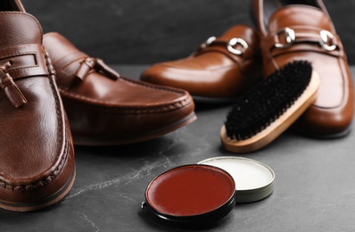 Shoe care accessories and footwear on black slate background, closeup