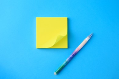 Photo of Blank paper note and pen on light blue background, flat lay