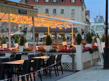 Photo of WARSAW, POLAND - JULY 15, 2022: Outdoor cafe terraces on Crowded Old Town Market Place in evening