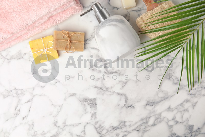 Flat lay composition with soap dispenser on white marble background. Space for text