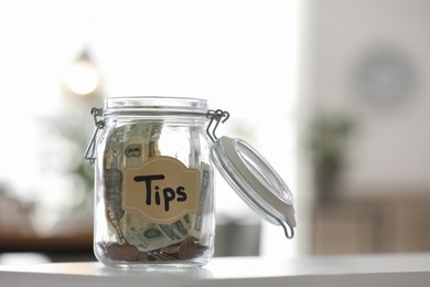 Glass jar with tips on table indoors
