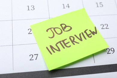 Reminder note about job interview on calendar, closeup