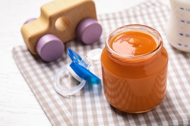 Healthy baby food in jar on table, closeup. Space for text