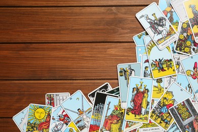 Tarot cards on wooden table, top view. Space for text
