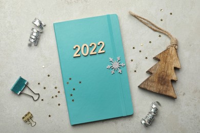 Turquoise planner, stationery and Christmas decor on light table, flat lay. Planning for 2022 New Year