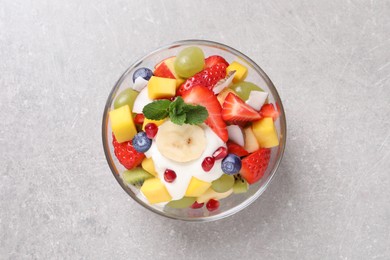 Delicious fruit salad on light grey table, top view