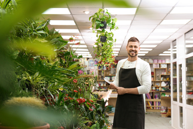 Photo of Male business owner with tablet in his flower shop