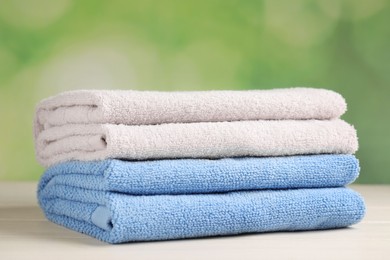 Soft folded towels on white wooden table