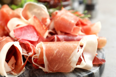 Pile of tasty prosciutto on table, closeup