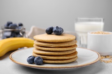Tasty oatmeal pancakes on grey table, closeup