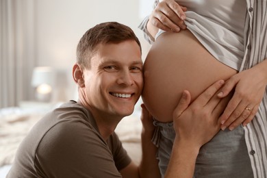 Young pregnant woman with her husband at home, closeup