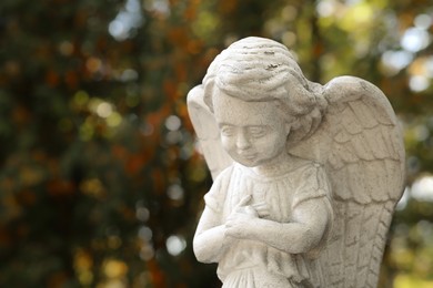 Beautiful statue of angel at cemetery, space for text