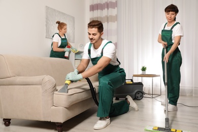 Team of professional janitors working in living room. Cleaning service