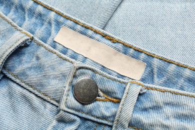 Blank clothing label on light blue jeans, top view