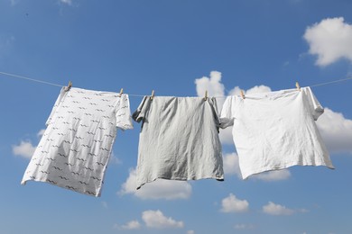 Washing line with clean clothes against sky. Drying laundry outside