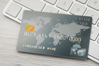 Photo of Online payment concept. Bank card and computer keyboard on white wooden table, closeup
