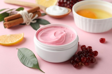 Fresh pomegranate and jar of facial mask on pink background. Natural organic cosmetics