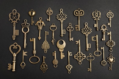 Flat lay composition with bronze vintage ornate keys on dark background