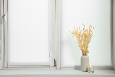 Photo of Window with blinds and dry plants on sill indoors