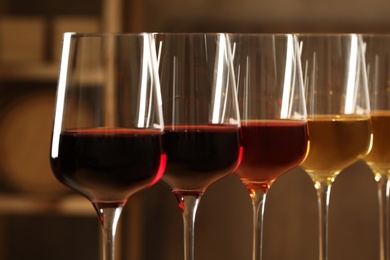 Glasses of different wines in cellar, closeup. Expensive collection