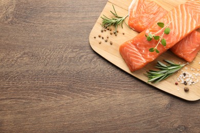 Photo of Fresh raw salmon and ingredients for marinade on wooden table, top view. Space for text
