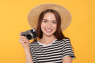 Photo of Young woman with camera on yellow background. Interesting hobby