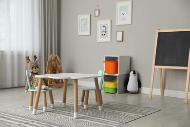 Child's room interior with stylish table, chairs and toys