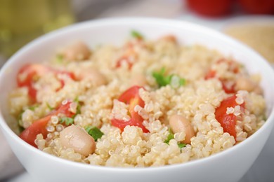 Photo of Delicious quinoa salad with tomatoes, beans and parsley, closeup