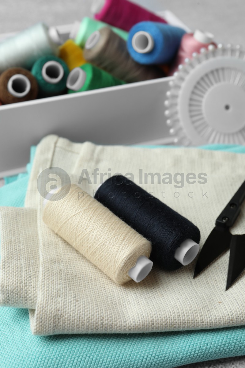 Spools of threads and sewing tools on table