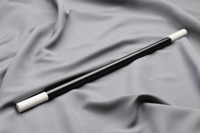 Beautiful black magic wand on grey fabric