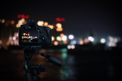 Taking photo of beautiful cityscape at night with camera mounted on tripod