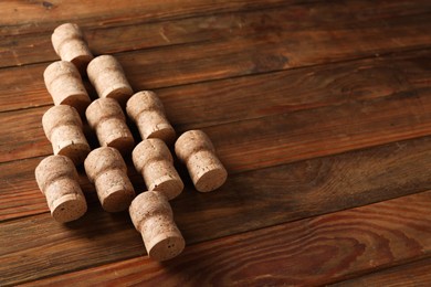 Photo of Christmas tree made of sparkling wine corks on wooden table. Space for text