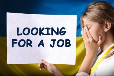 Image of Unemployed due to war. Sad woman holding sign with phrase Looking For A Job against Ukrainian flag