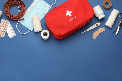 Flat lay composition with first aid kit on blue background, space for text