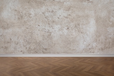 Wooden floor and empty grey wall indoors