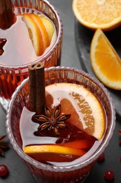 Photo of Aromatic punch drink and ingredients on black table, above view