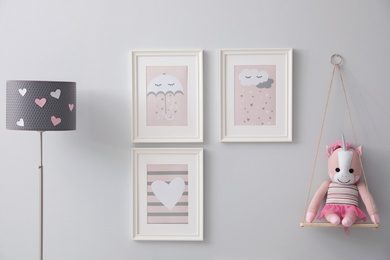 Kid's toy and beautiful pictures on grey wall