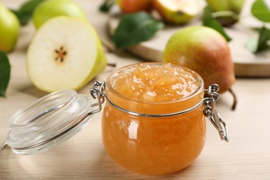 Tasty homemade pear jam and fresh fruits on wooden table