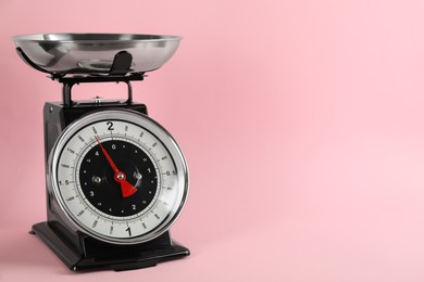 Retro mechanical kitchen scale on pink background, space for text