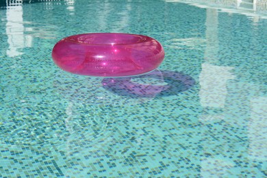 Inflatable ring floating on water in swimming pool