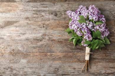 Blossoming lilac on wooden background, top view. Spring flowers