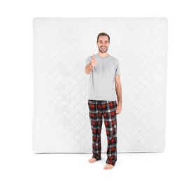 Young man with comfortable mattress isolated on white