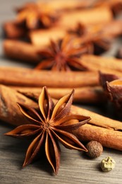 Aromatic anise stars, pepper and cinnamon sticks on wooden table