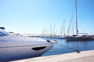 Modern boats near pier and clear blue sky