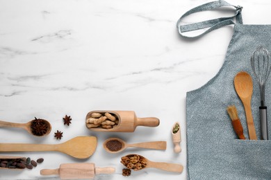 Photo of Flat lay composition with grey apron, ingredients and kitchen utensils on white marble table. Space for text